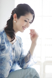 蘆久保慶那女士穿著淺藍色衣服，從側面拍攝，她是日籍成熟美女服裝模特兒，她的身高是170厘米，身材十分苗條俏麗。