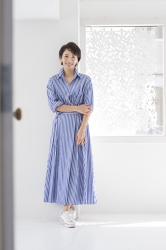 珀紀是穿著藍白豎條紋連衣裙的日本成熟女性時裝模特兒，她站著。