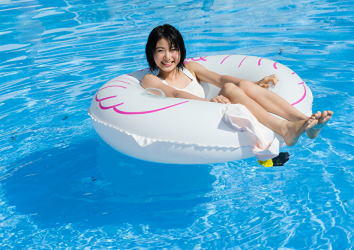 夏陽穿著白色比基尼泳衣，在救生圈上漂浮在水池上，她是日本美麗可愛『模特兒・女演員』。