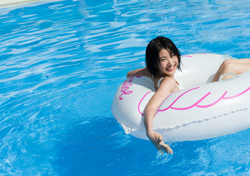 夏陽穿著白色比基尼泳衣，在救生圈上漂浮在水池上，她是日本美麗可愛『模特兒・女演員』。