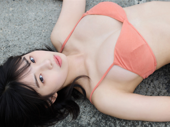 菊沖姬羅小姐是『日本・亞洲』的『凹版偶像・寫真偶像・泳裝偶像｜比基尼泳裝模特兒・海報模特兒｜女演員』，她在海灘上，她穿著橙色比基尼泳裝，躺在海灘的混凝土上。