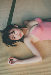 大慈彌杏實小姐是一位年輕的凹版偶像（泳裝女模 / 平面寫真偶像 / 寫真女優），也是一位年輕可愛的女演員，她穿著粉色緊身連衣褲，躺在榻榻米墊上。