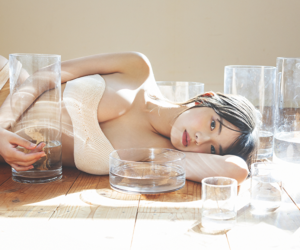 菊沖姬羅小姐是『日本・亞洲』的『凹版偶像・寫真偶像・泳裝偶像｜泳裝模特兒・泳衣女模・海報女郎｜女演員』，她身穿白色比基尼泳衣，躺在地上，幾個玻璃杯排成一排。