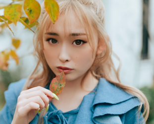 古濱優來小姐穿著藍色衣服在戶外，但拍到她的臉很大，她有一片落葉，她是一位高大的白辣妹日本時裝模特兒，T台模特兒，泳裝模特兒（凹版偶像・海報女郎・比基尼泳衣模特兒），電視藝人和YouTuber。